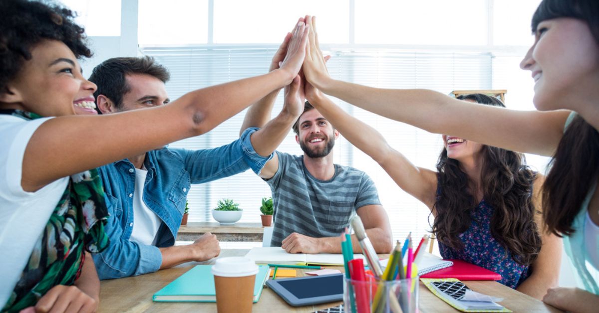 Small group of people all giving each other a high five