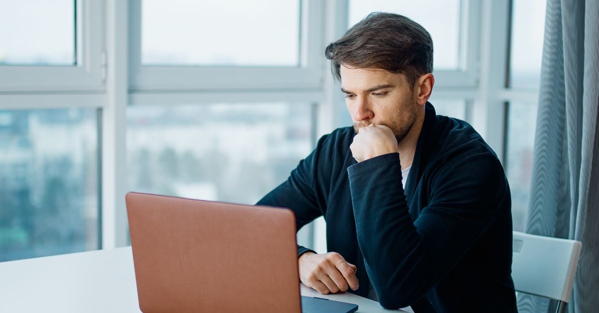 Man thinking at a laptop