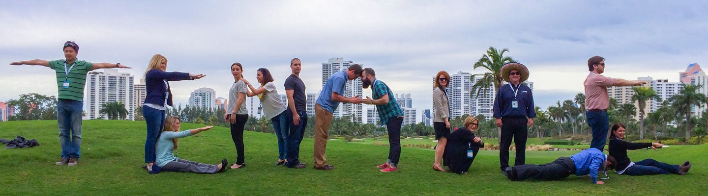A group of people outside spelling Tenable using their bodies