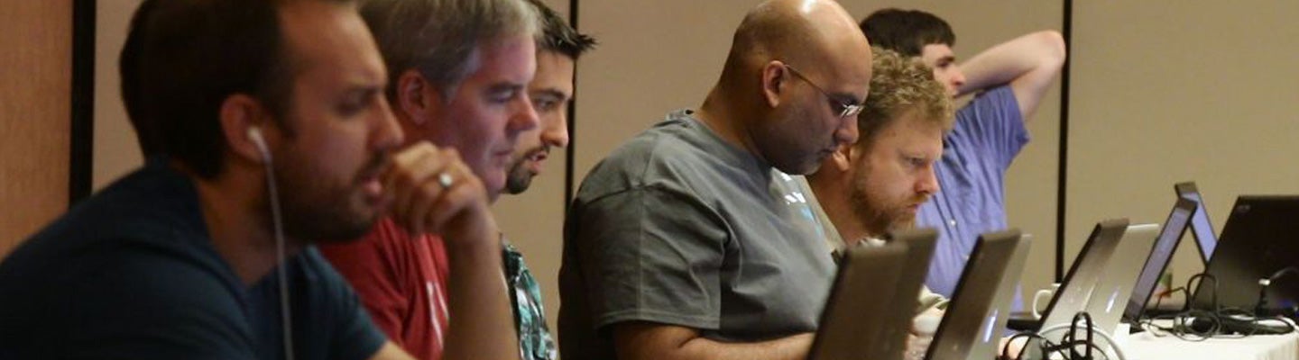Profile view of a group of people looking at laptop computers