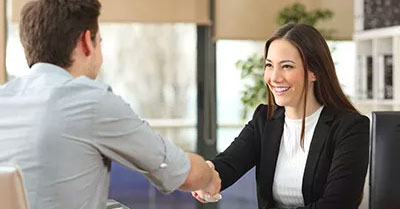 Woman in a suit shaking hands with another person