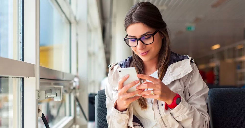 Women sitting by a window looking at her smartphone