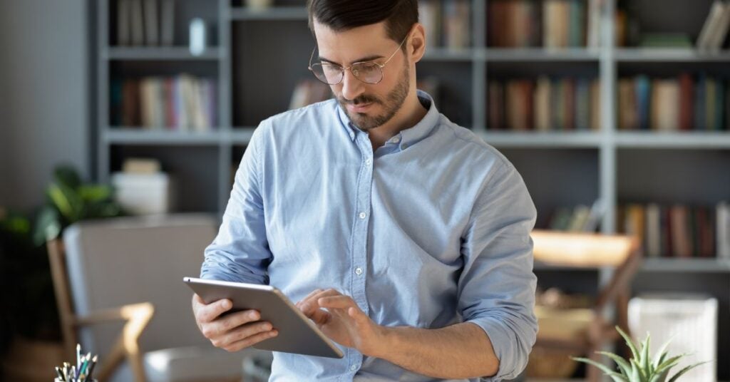 Man clicking onto a tablet