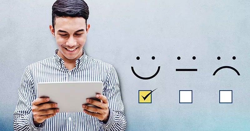 Man reading a tablet next to happy and sad emojis