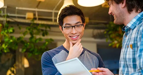 Two men looking at a report