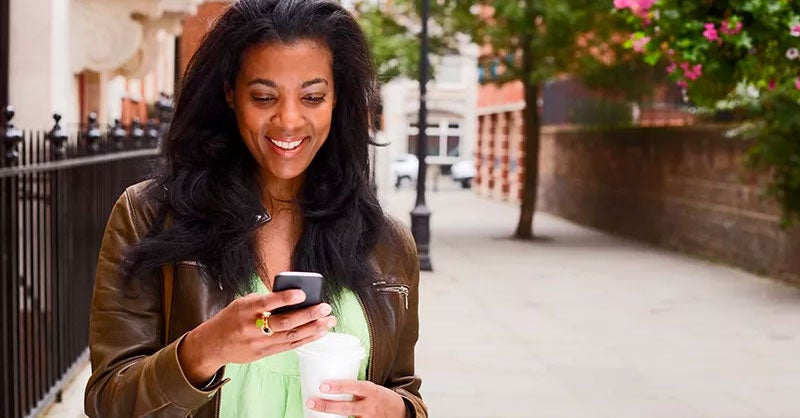 Women standing outside looking at her smartphone