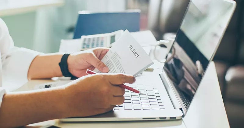 Pair of hands holding a paper resume