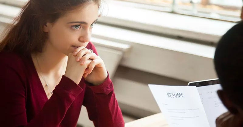 Woman sitting across the desk from a person holding her resume