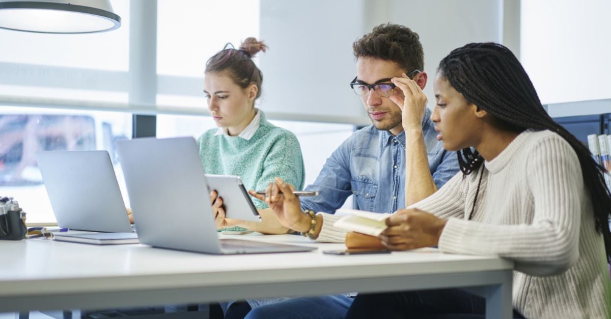 People at a table looking at tablets