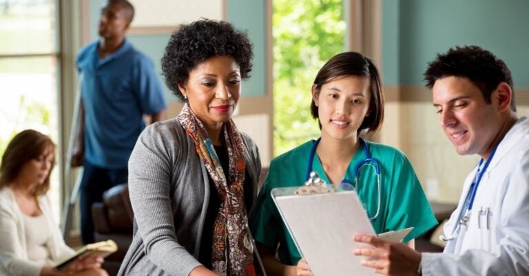 Two women reading a report on a clipboard