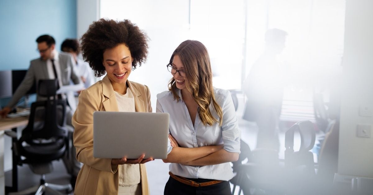 Two woman looking over a laptop