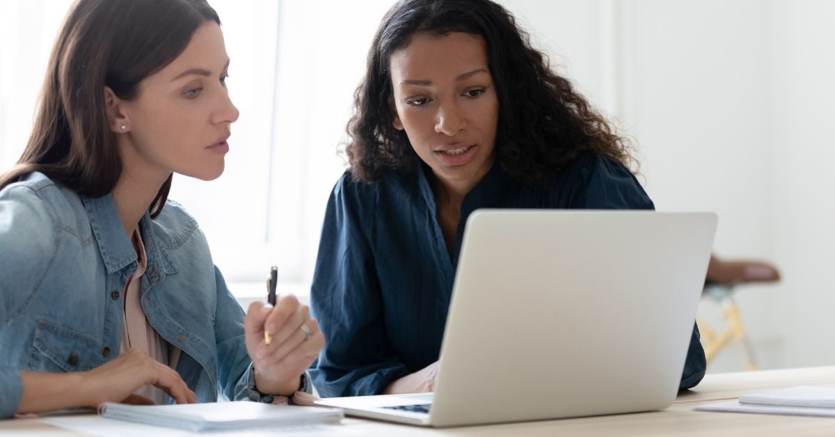 Two women looking over a laptop