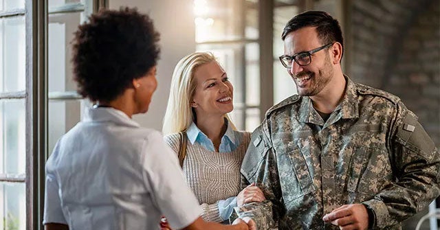 Man in military clothes shaking another person's hand