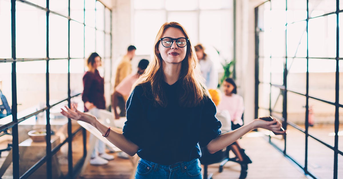 Women standing in a glass office with her hands outstretched