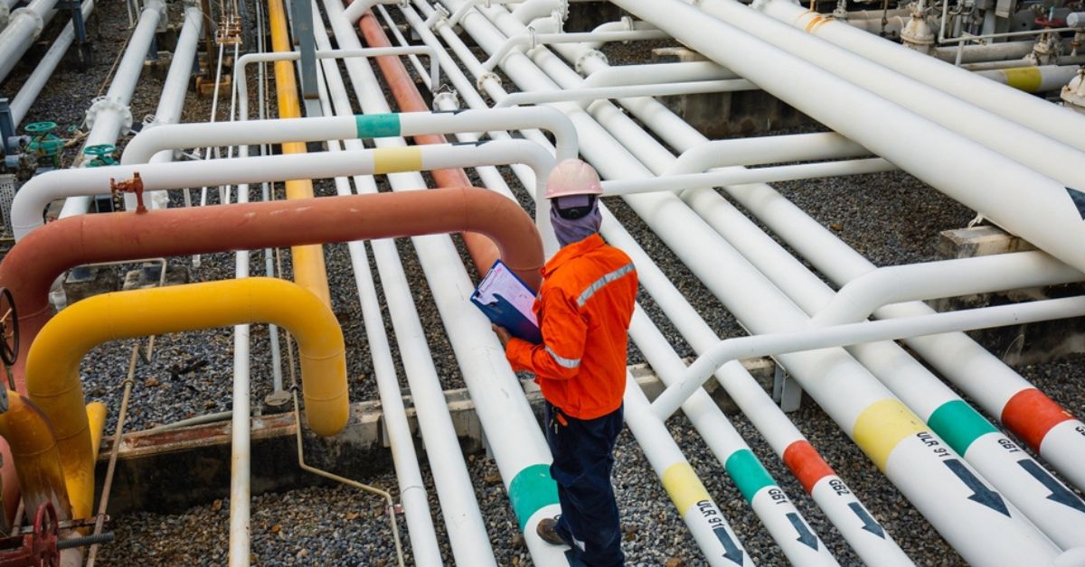 Man working outside surrounded by pipes