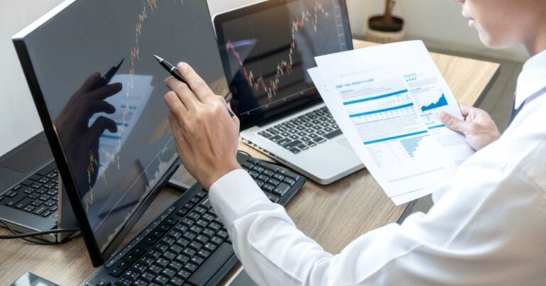 Hand pointing to a computer monitor