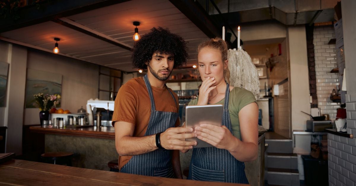 Two people reading on a tablet