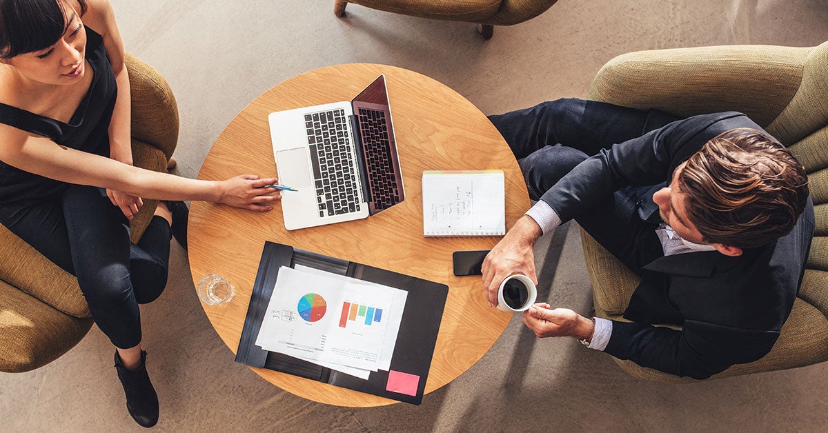 Overhead photos of two people talking at a small round wooden table