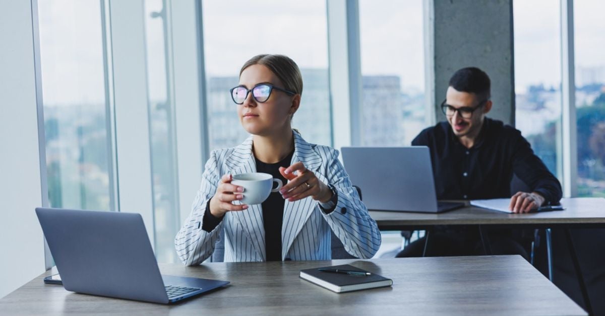 Woman drinking coffee at a desk