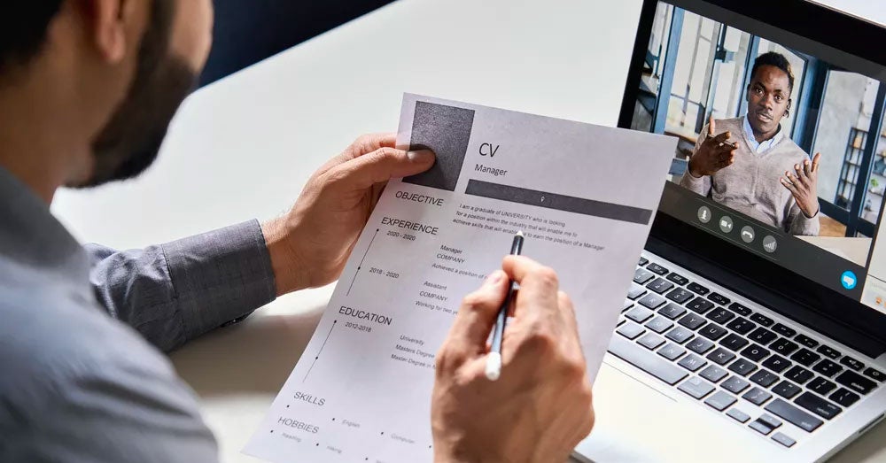 Person holding a printed resume while on a video call