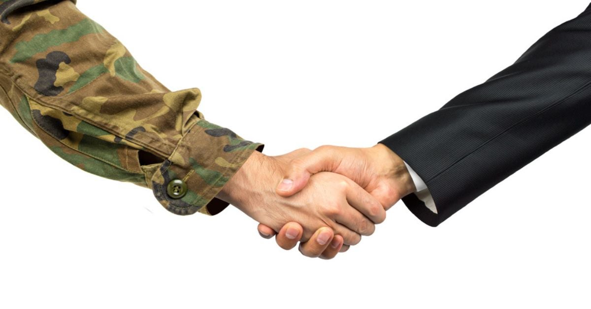 Military hand shaking a hand in a suit