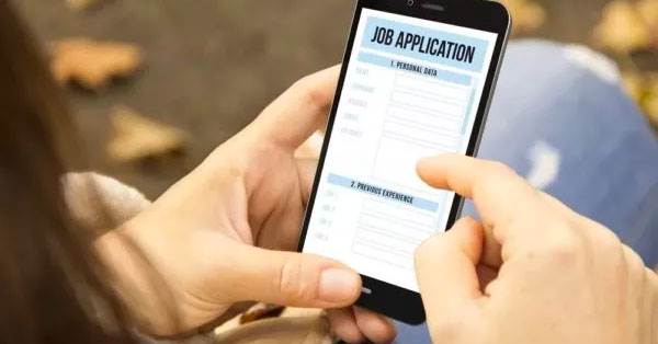 Hand holding a phone with a job application on the screen