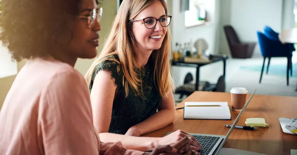 Two women working together at a laptop