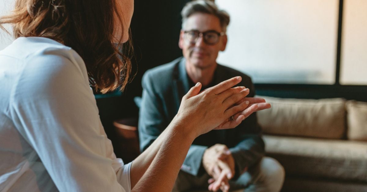 Woman waving her hands while talking to a man