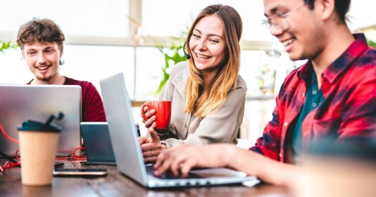 Smiling people reading information on a laptop