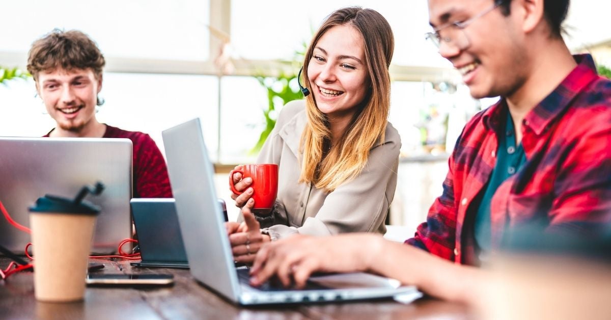 Smiling people reading information on a laptop