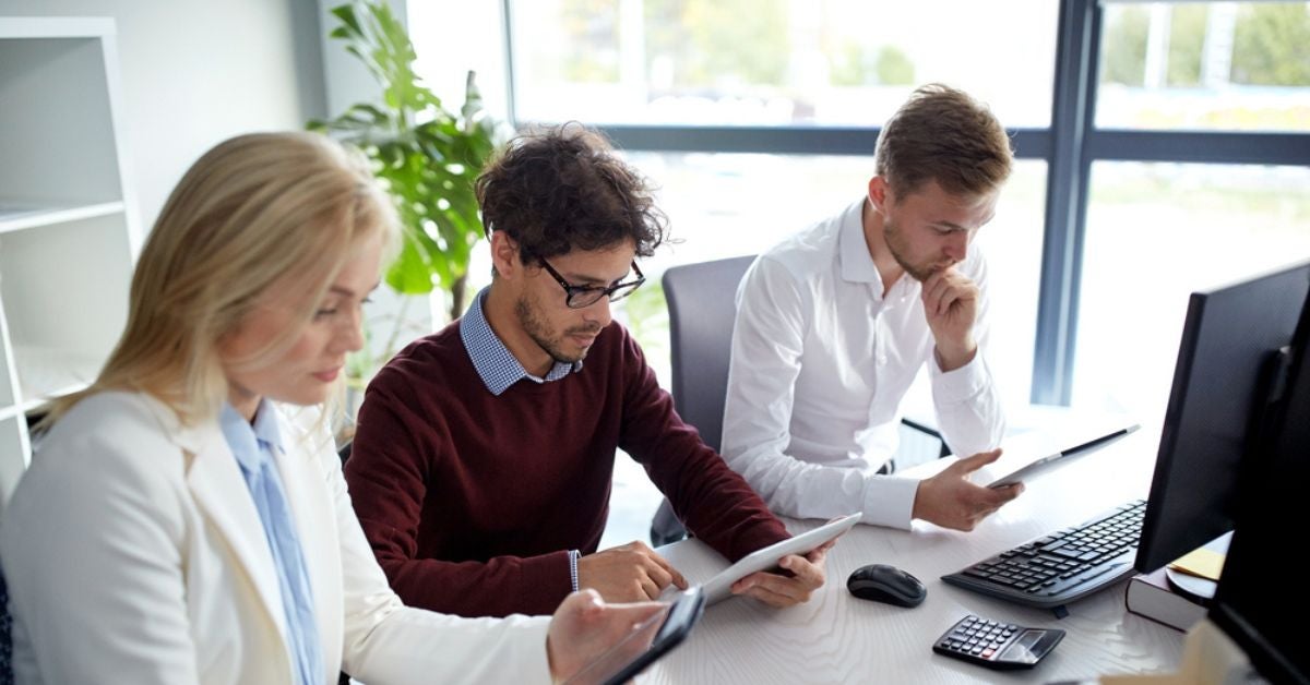 Three people looking at documents in their hands