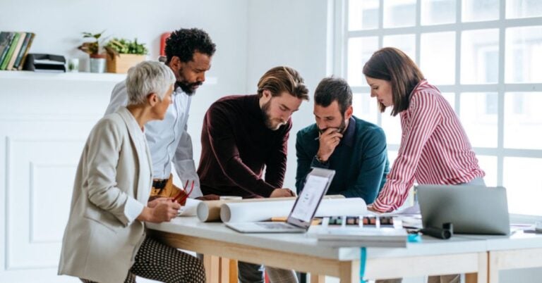 People studying plans on a table