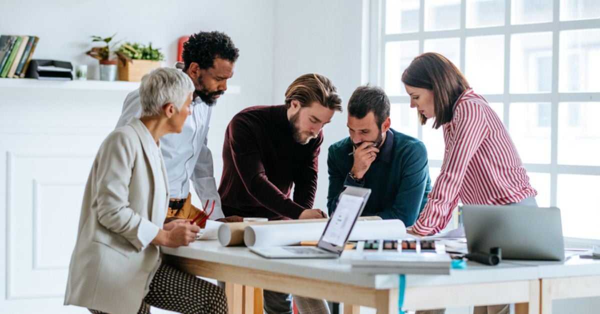 People studying plans on a table