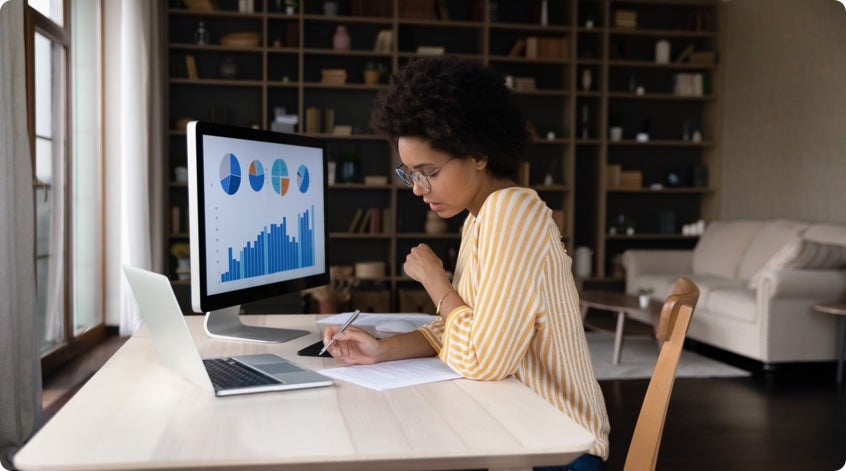 Women in a living room office taking notes about graphical data