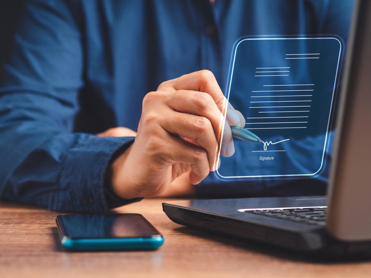 Business Man Signing with a Pen on a Visual Representation of an Electronic Signature