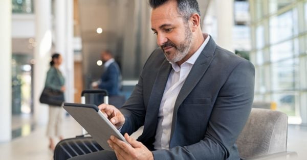 Working man, sitting, reading on an iPad