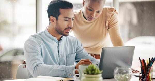 Diverse professionals reviewing hiring data from a laptop