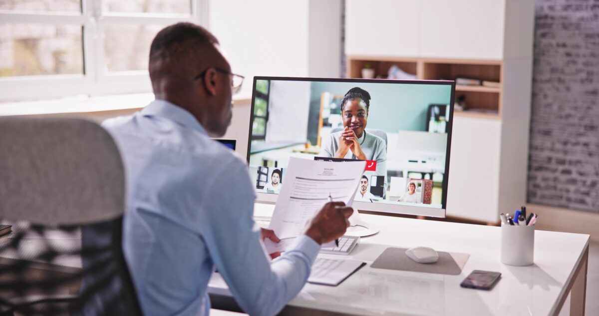Talent Acquisition Manager Interviewing Candidate via Video Call While Reviewing Candidate Resume