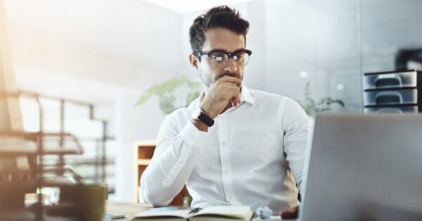 Professional man deep in thought looking at computer