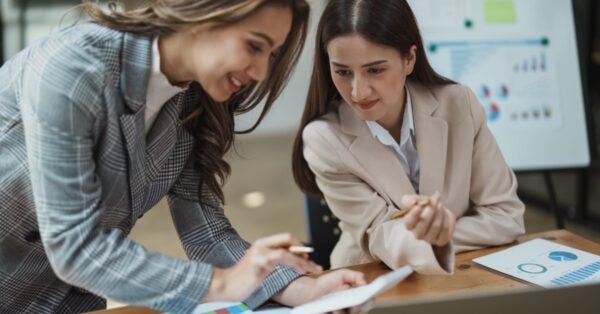 Two female coworkers evaluating data to make hiring decisions