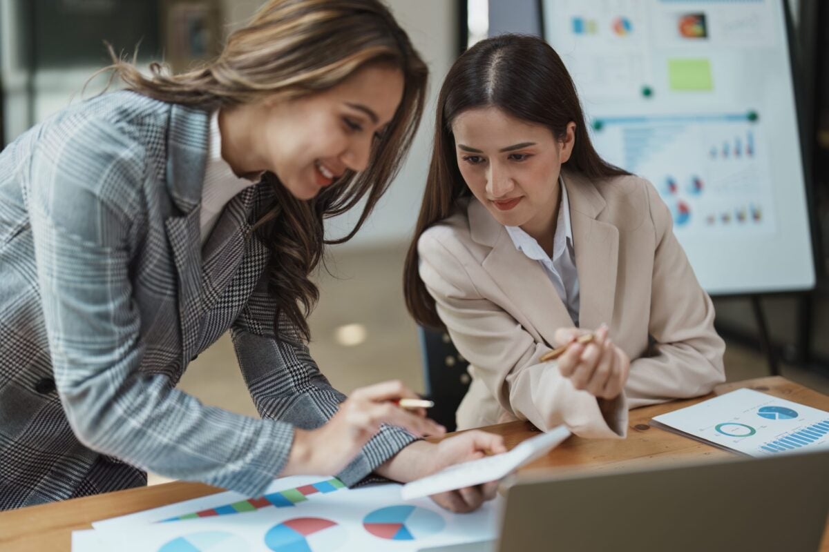 Two female coworkers evaluating data to make hiring decisions