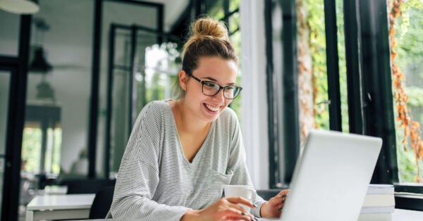 smiling professional works on laptop