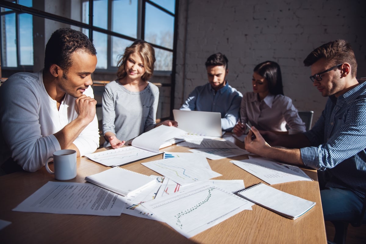 Group of hiring managers sitting at a table discussing talent acquisition strategy