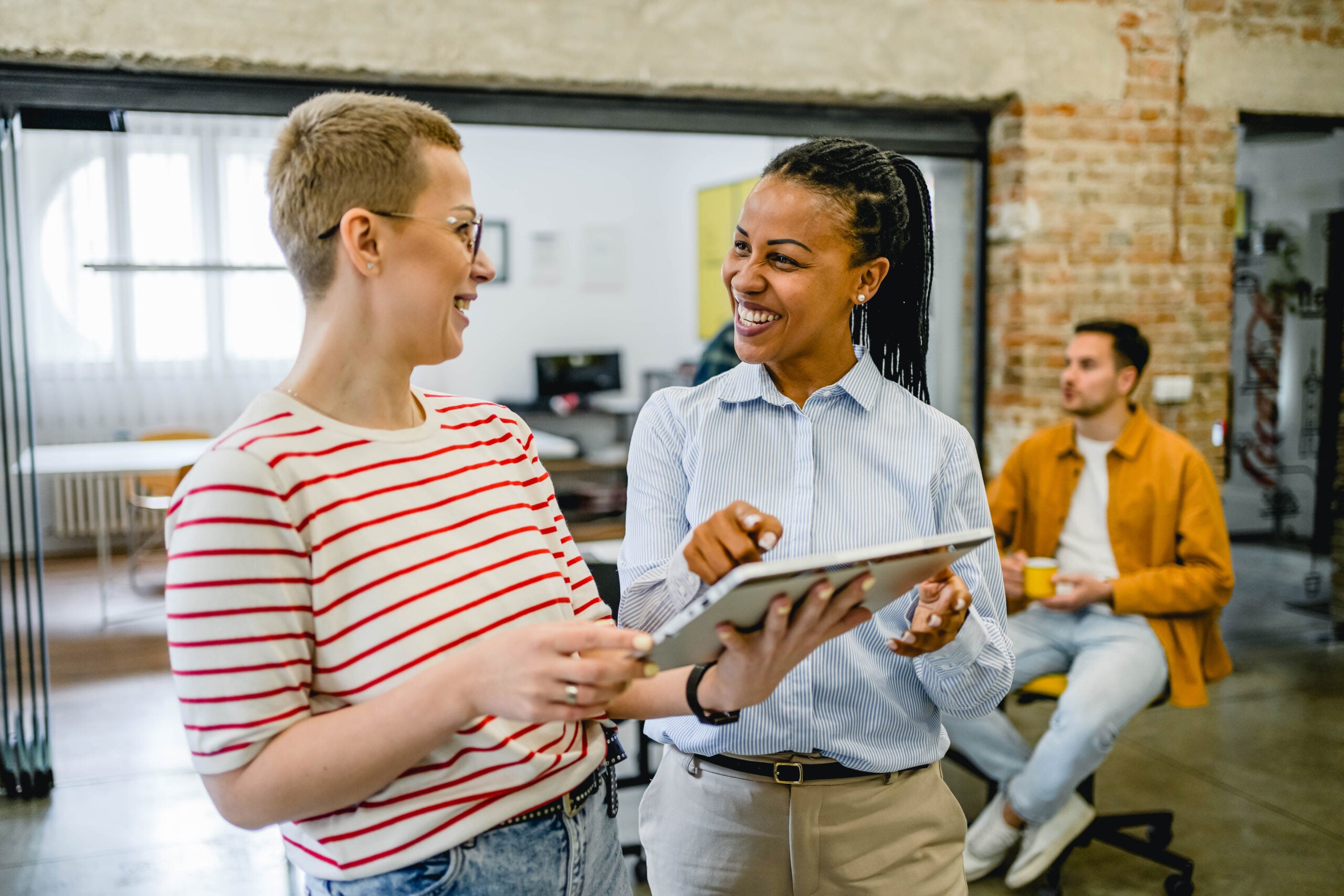 Happy Talent Acquisition professionals discussing AI in hiring/recruiting software